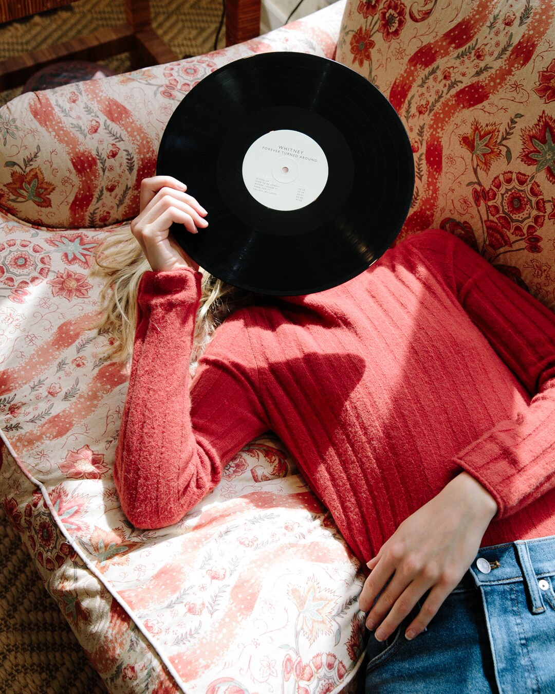 Girl on the couch with a record in her hands.