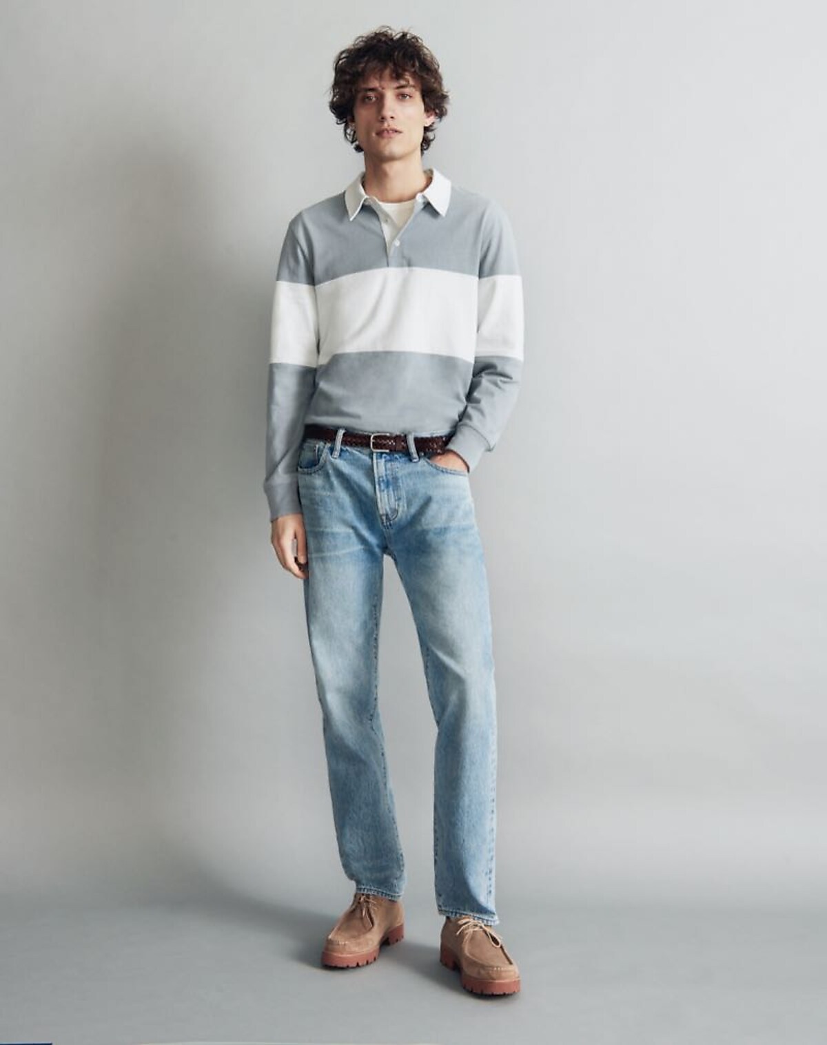 man in pale wash straight leg jeans and a sweater
