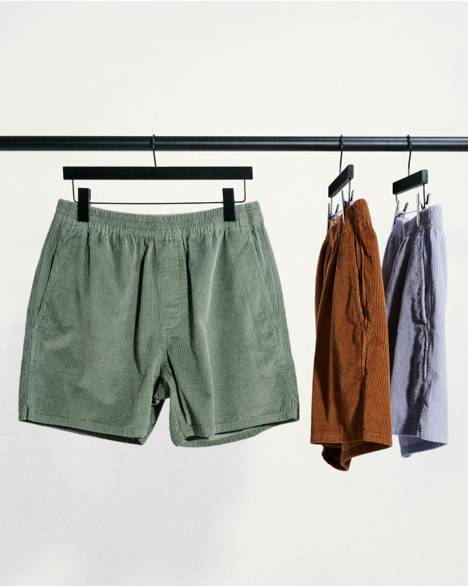 3 shorts on hangers, green, red, and blue
