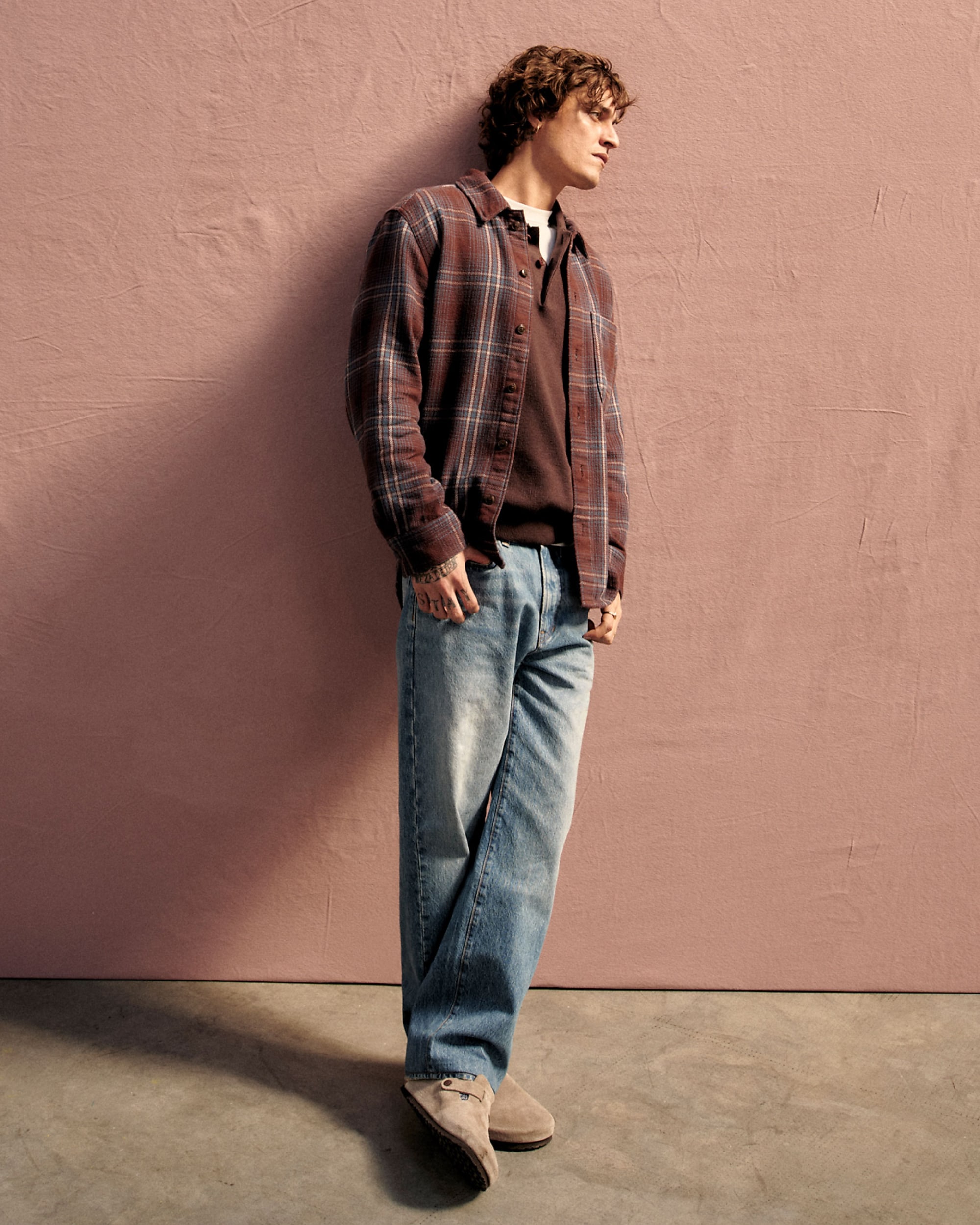 man standing in front of a parachute with classic beige shorts, white top, and a beige shirt