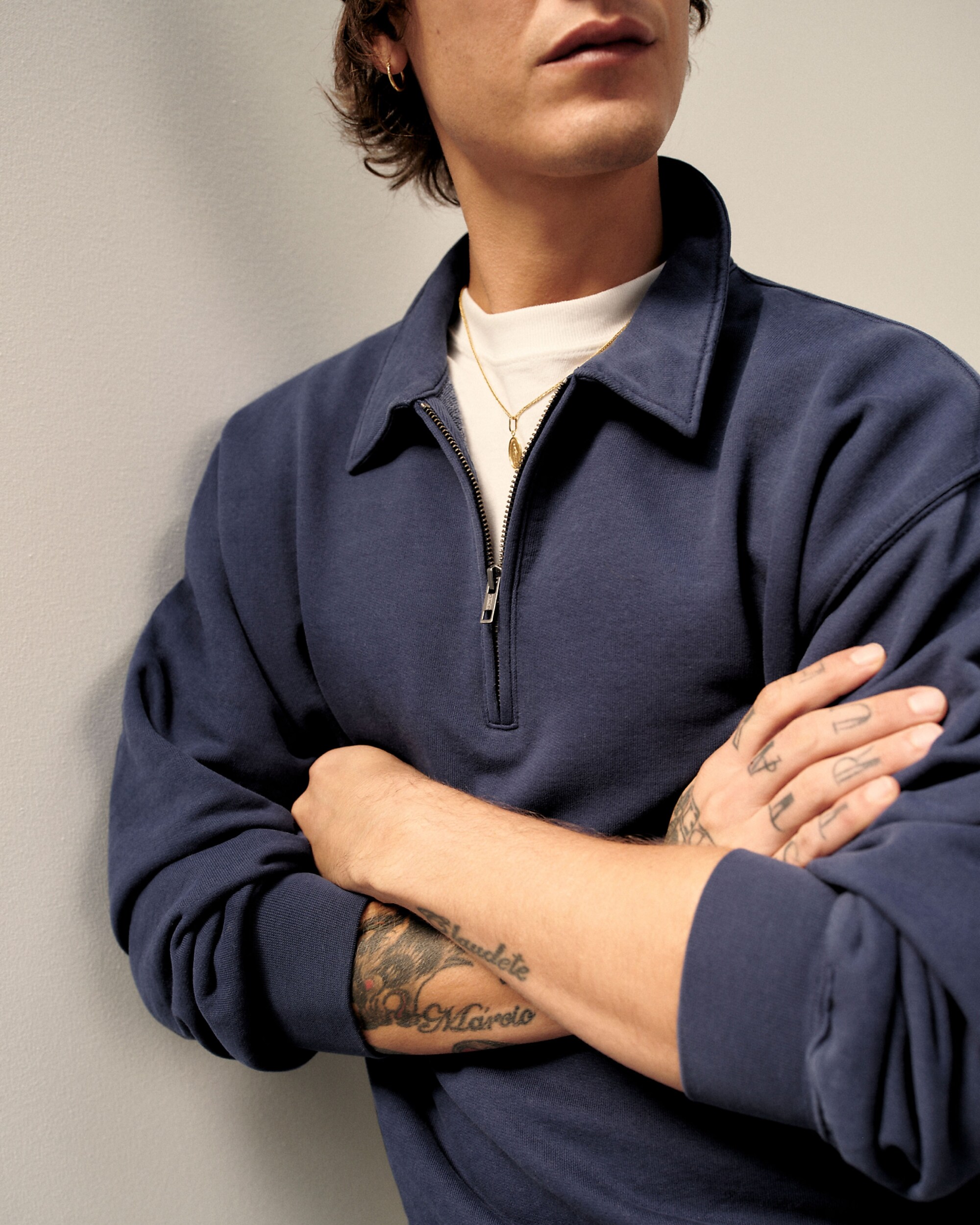 man standing in front of a parachute with classic beige shorts, white top, and a beige shirt