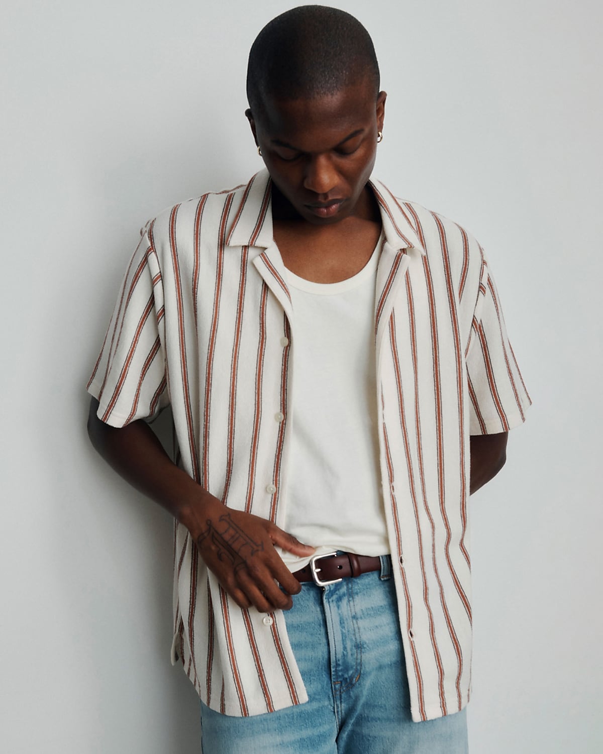 man wearing jeans, and striped short sleeve collared shirt