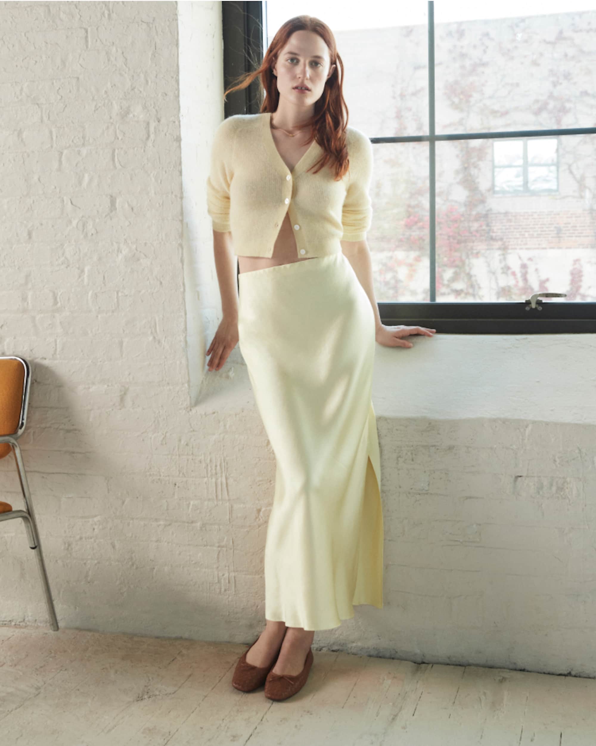 man standing in front of a parachute with classic beige shorts, white top, and a beige shirt