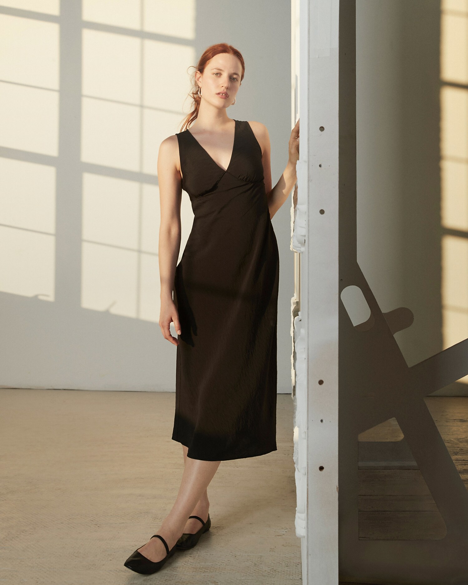 man standing in front of a parachute with classic beige shorts, white top, and a beige shirt