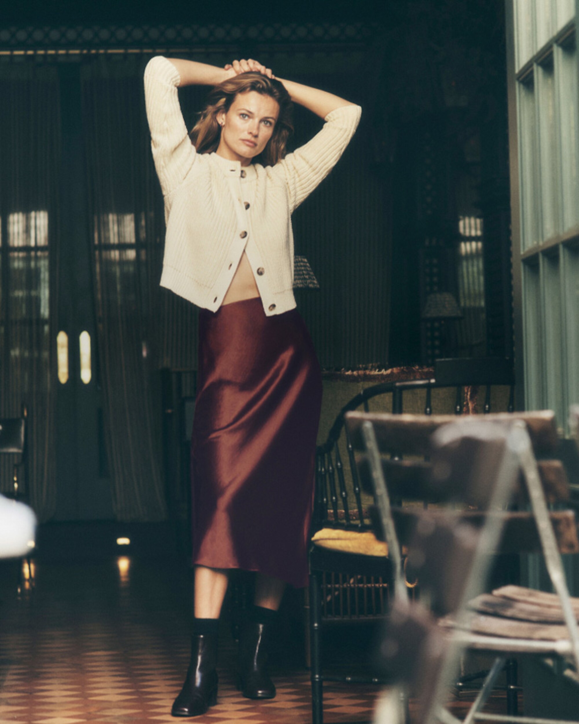 man standing in front of a parachute with classic beige shorts, white top, and a beige shirt