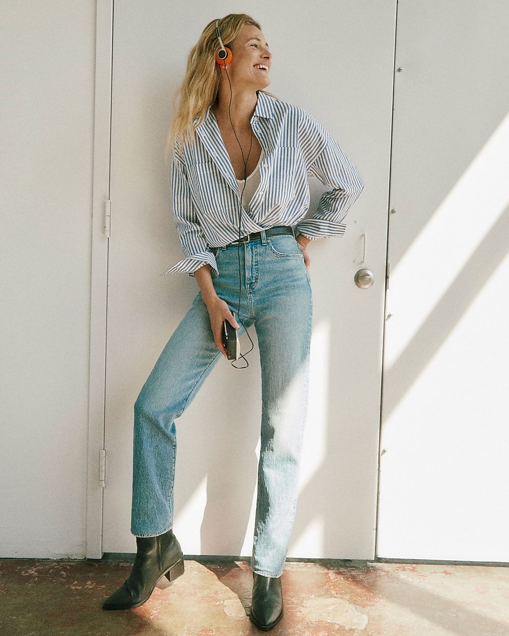 man standing in front of a parachute with classic beige shorts, white top, and a beige shirt