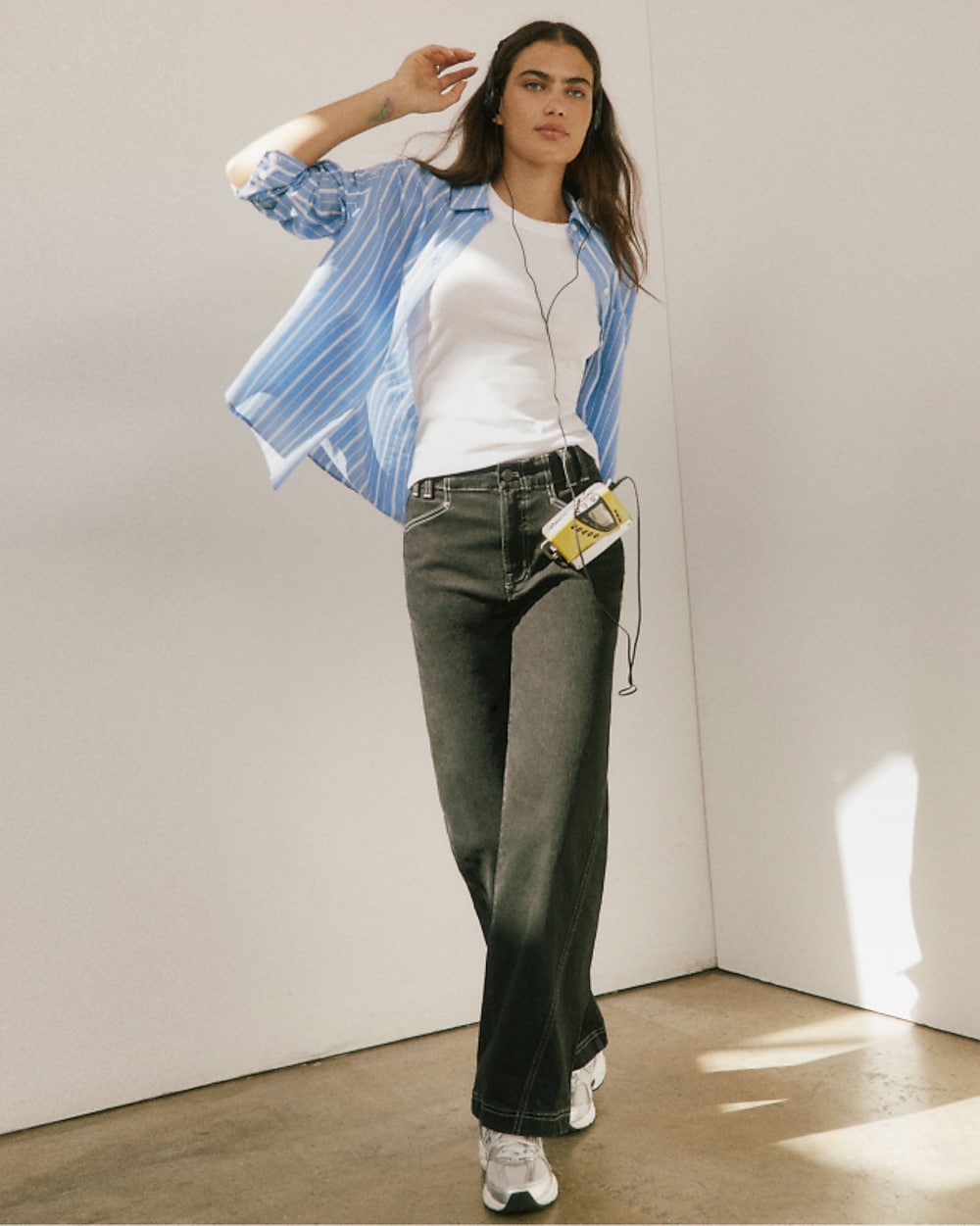 man standing in front of a parachute with classic beige shorts, white top, and a beige shirt