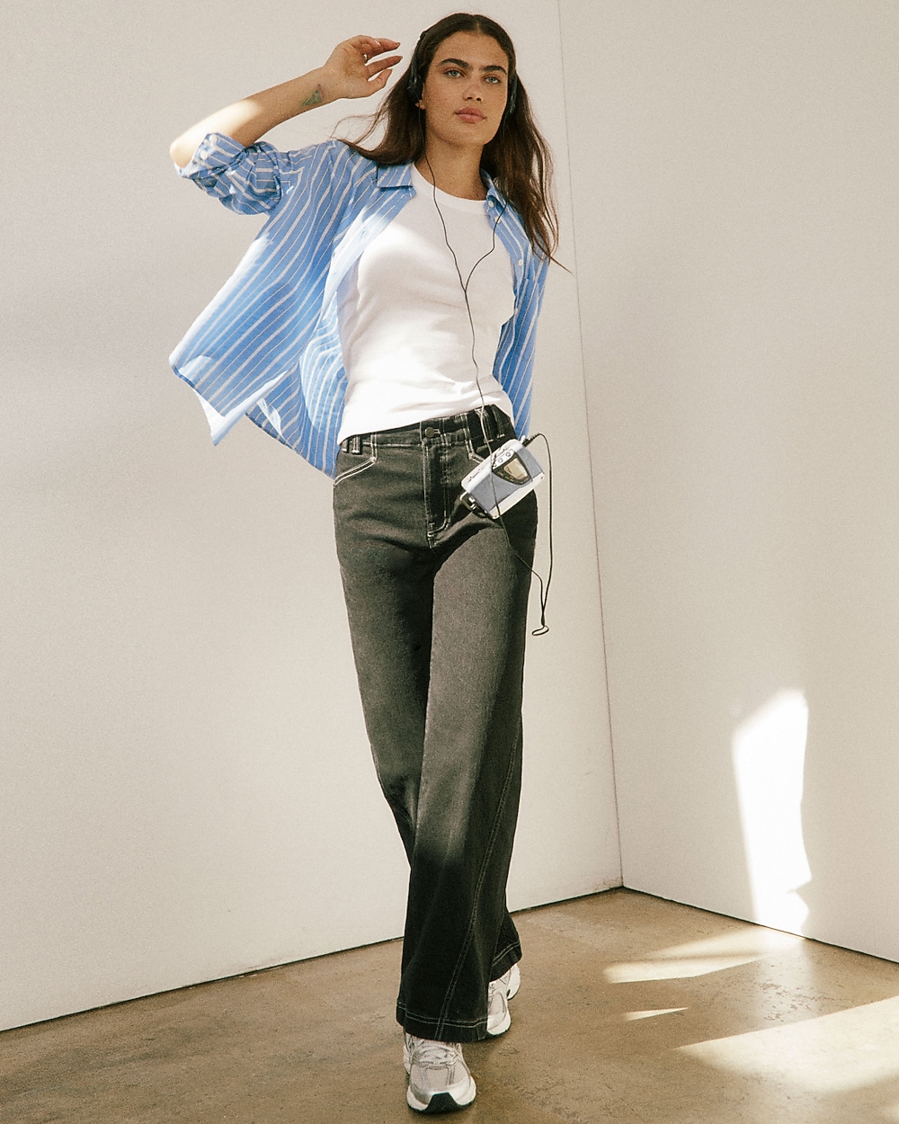 man standing in front of a parachute with classic beige shorts, white top, and a beige shirt