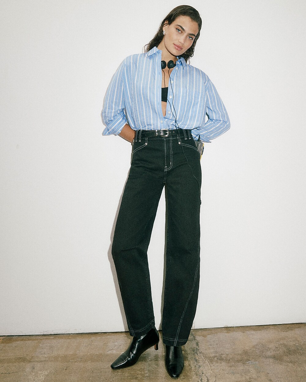 man standing in front of a parachute with classic beige shorts, white top, and a beige shirt