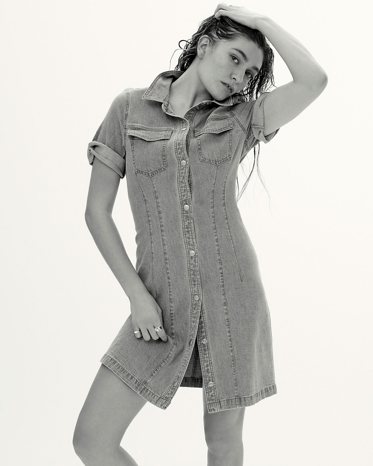man standing in front of a parachute with classic beige shorts, white top, and a beige shirt