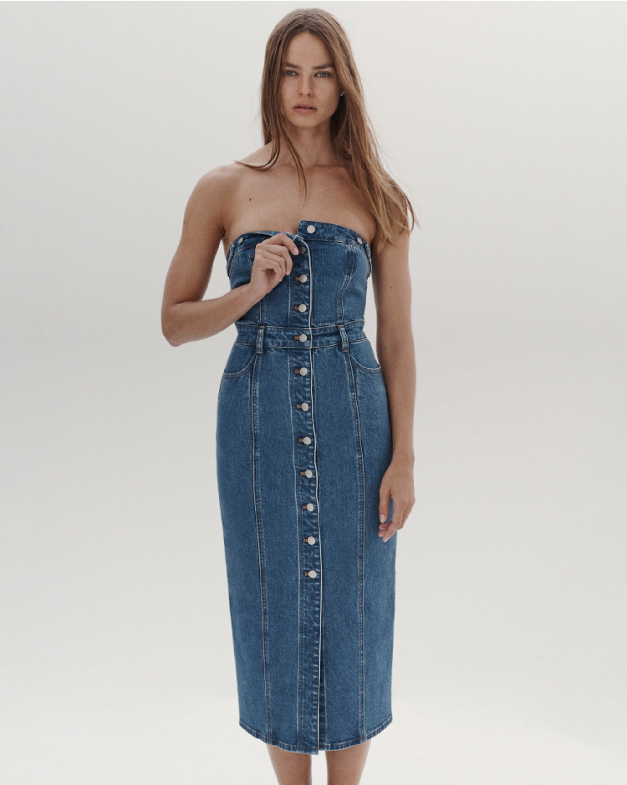 man standing in front of a parachute with classic beige shorts, white top, and a beige shirt