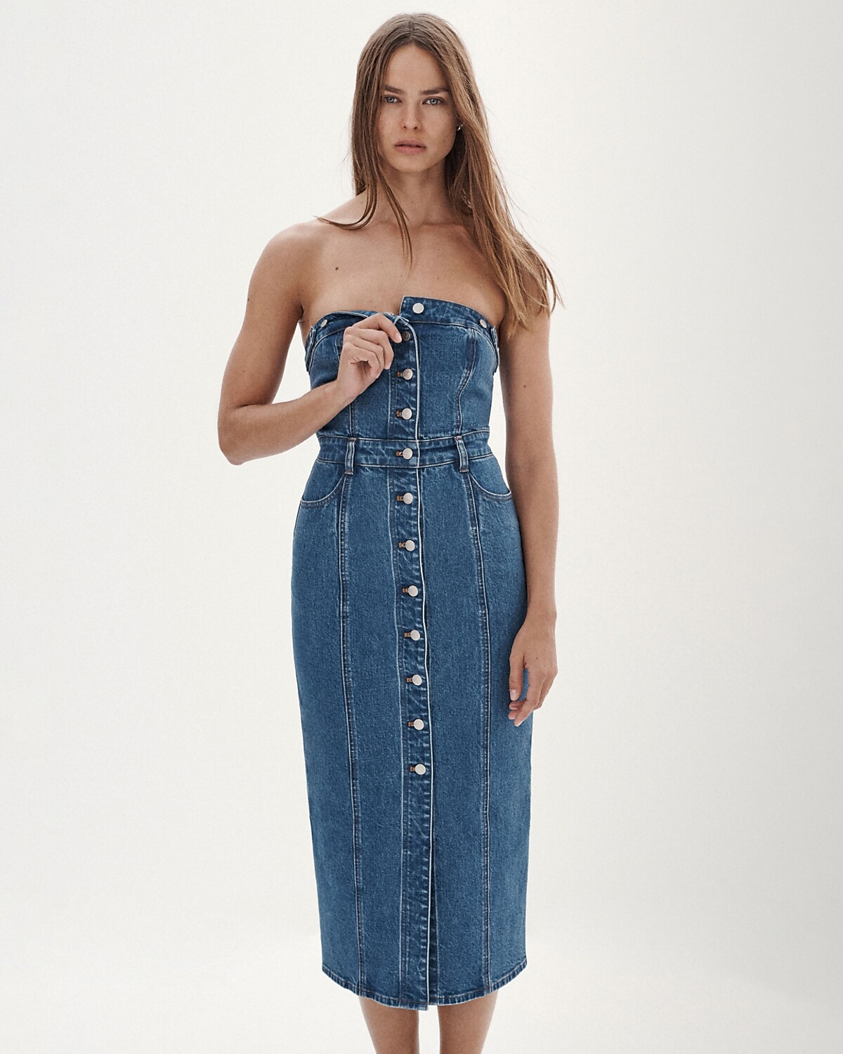 man standing in front of a parachute with classic beige shorts, white top, and a beige shirt