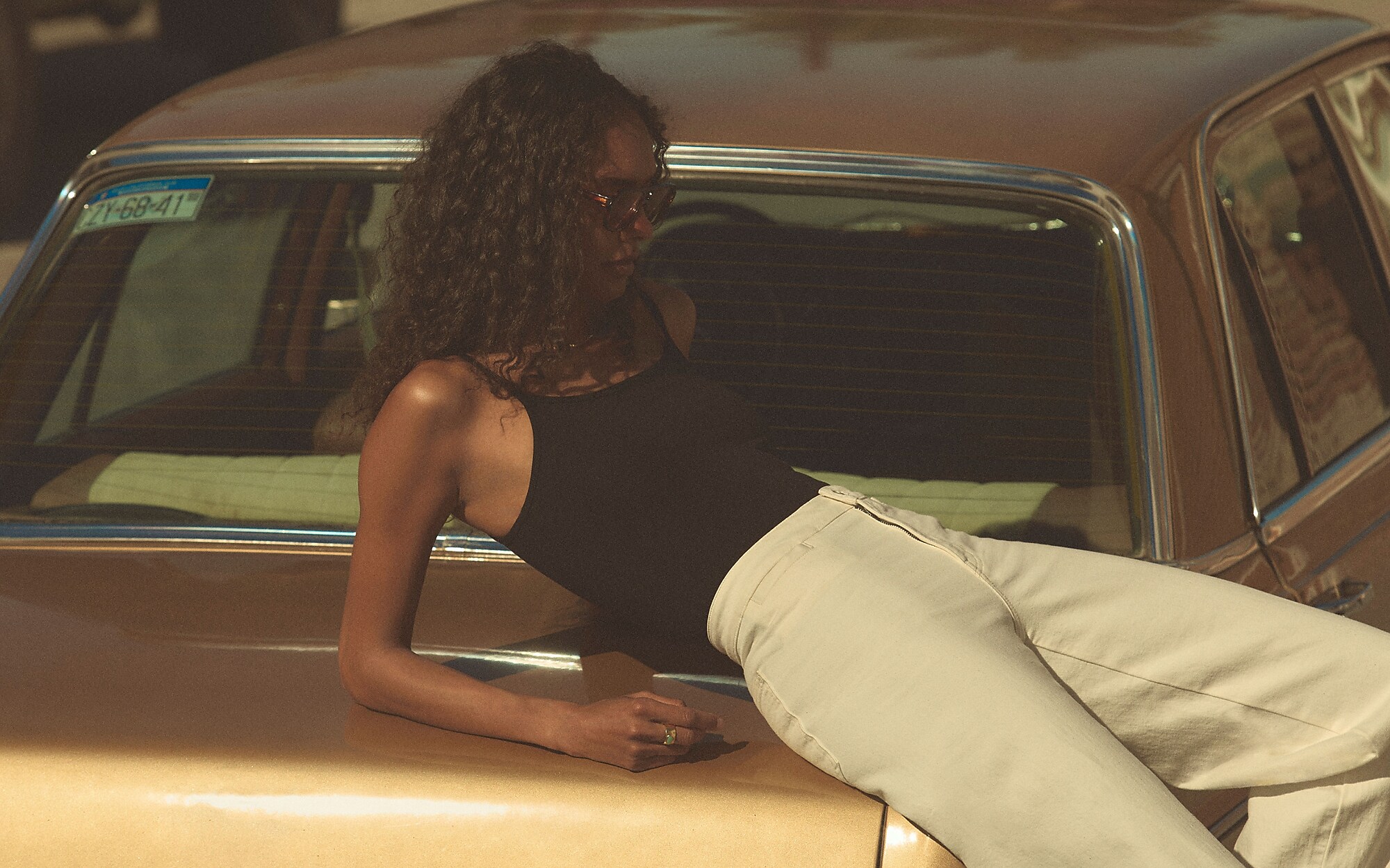 man standing in front of a parachute with classic beige shorts, white top, and a beige shirt