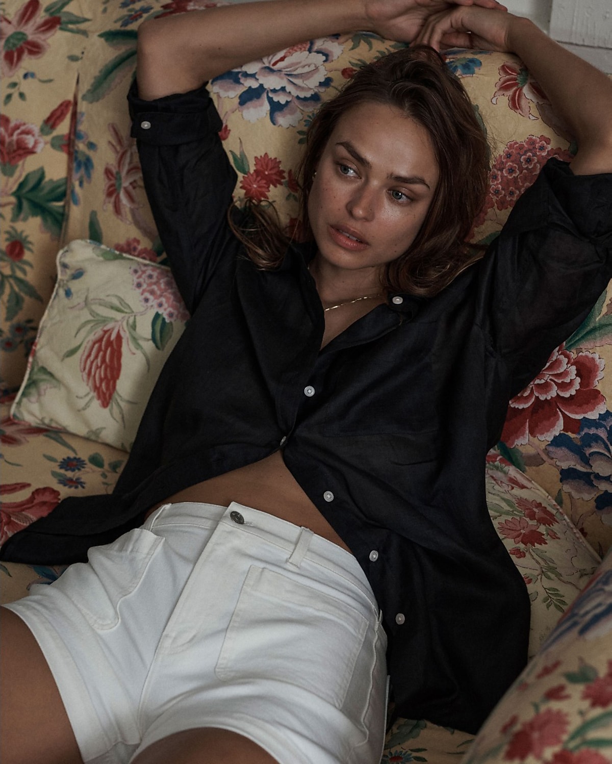 man standing in front of a parachute with classic beige shorts, white top, and a beige shirt