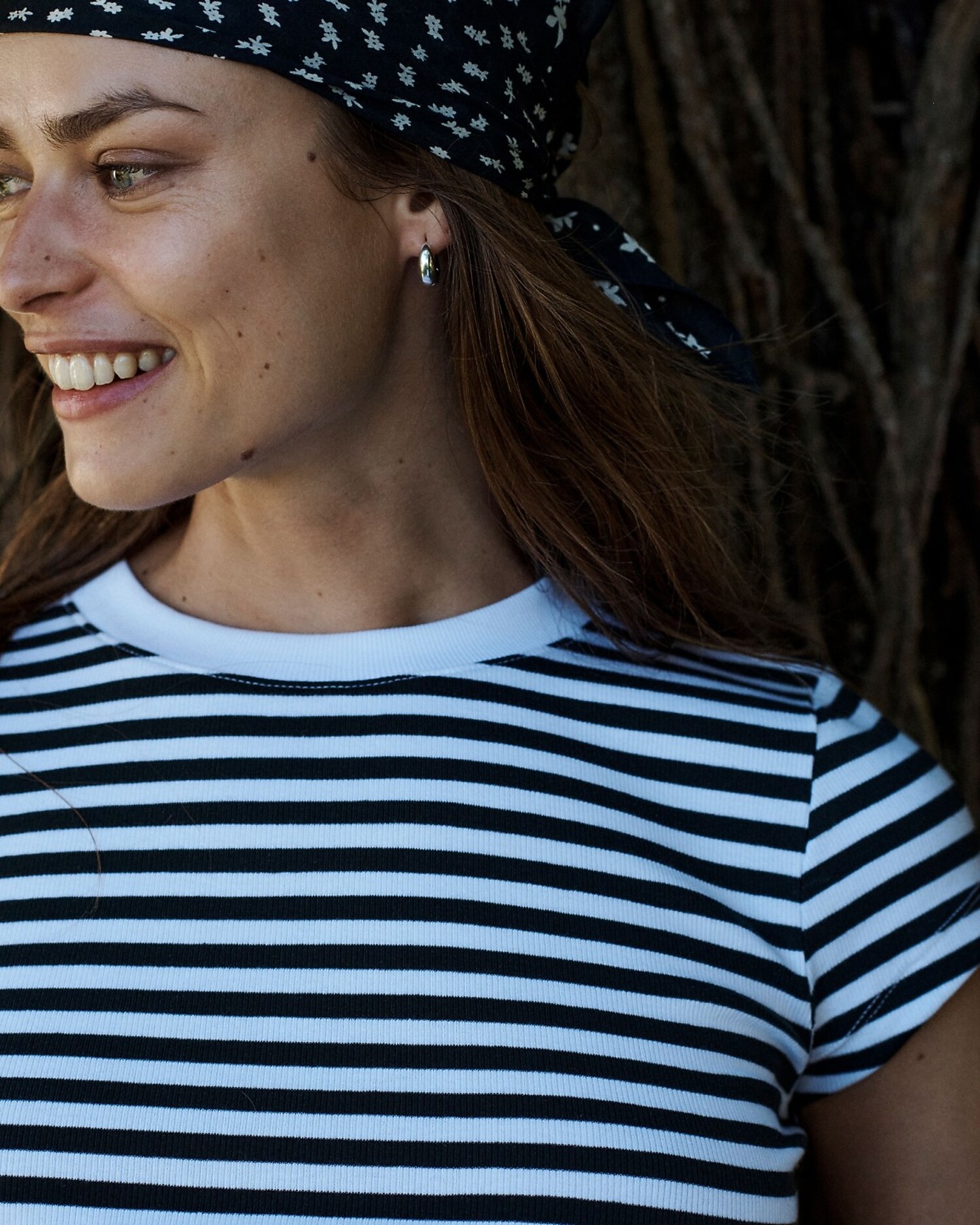 man standing in front of a parachute with classic beige shorts, white top, and a beige shirt