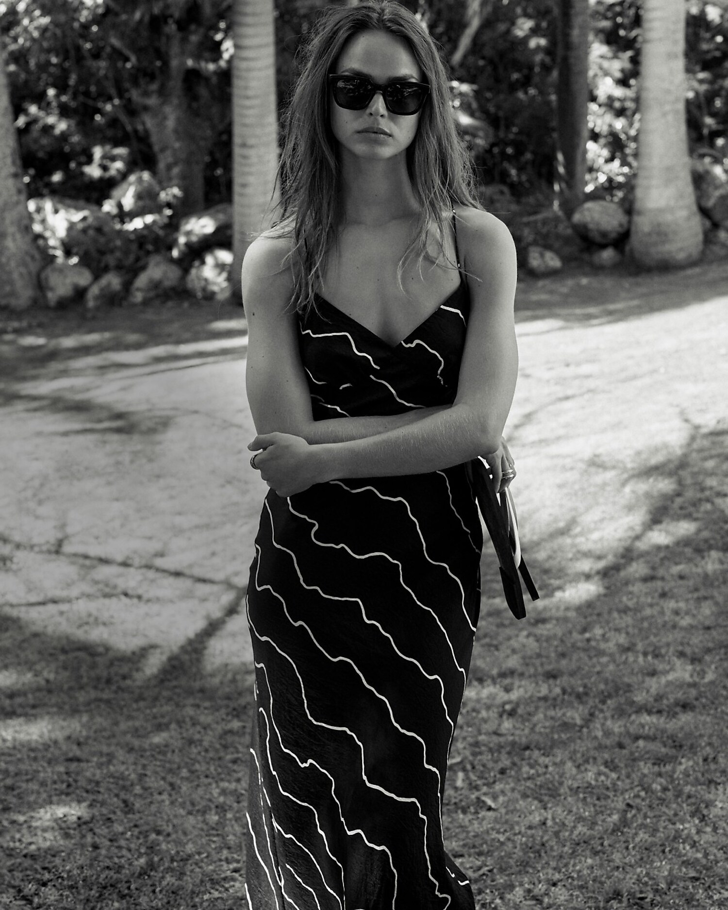 man standing in front of a parachute with classic beige shorts, white top, and a beige shirt