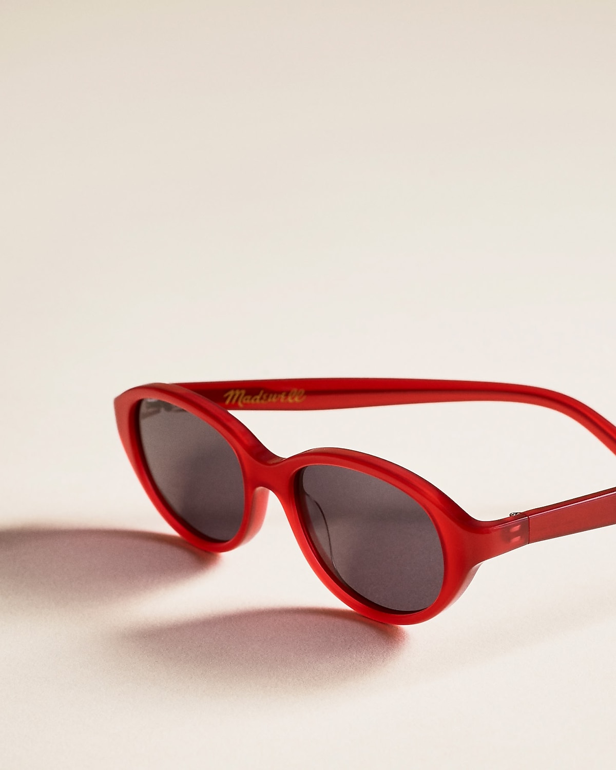 man standing in front of a parachute  with classic beige shorts, white top, and a beige shirt