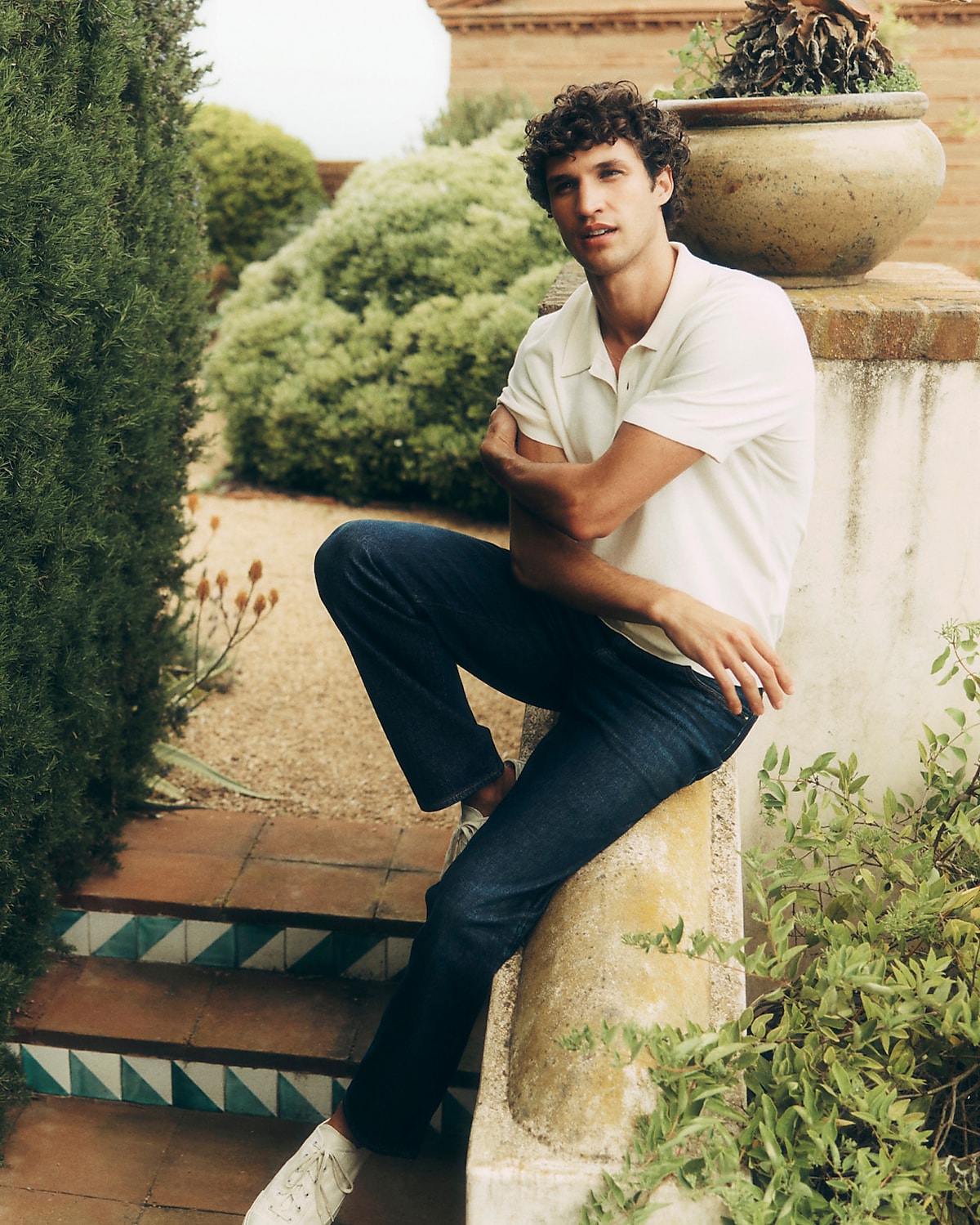 man standing in front of a parachute with classic beige shorts, white top, and a beige shirt