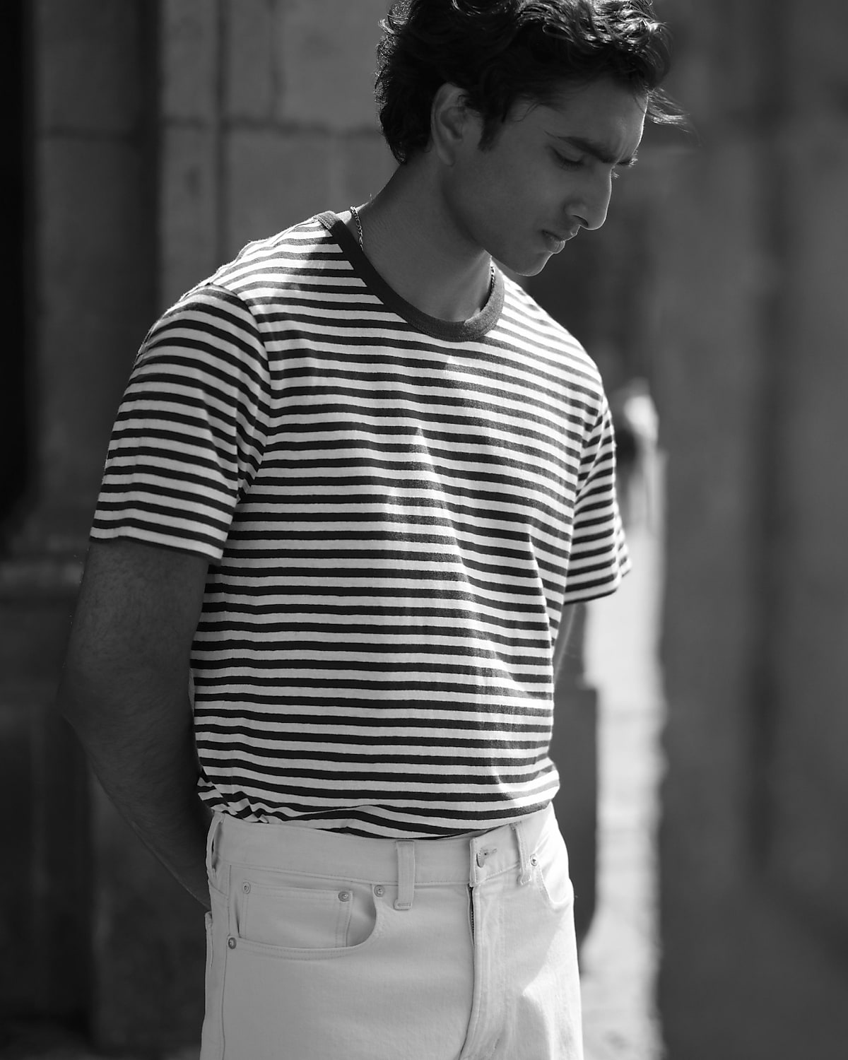 man standing in front of a parachute with classic beige shorts, white top, and a beige shirt