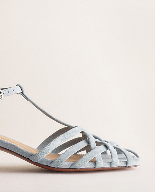 man standing in front of a parachute with classic beige shorts, white top, and a beige shirt