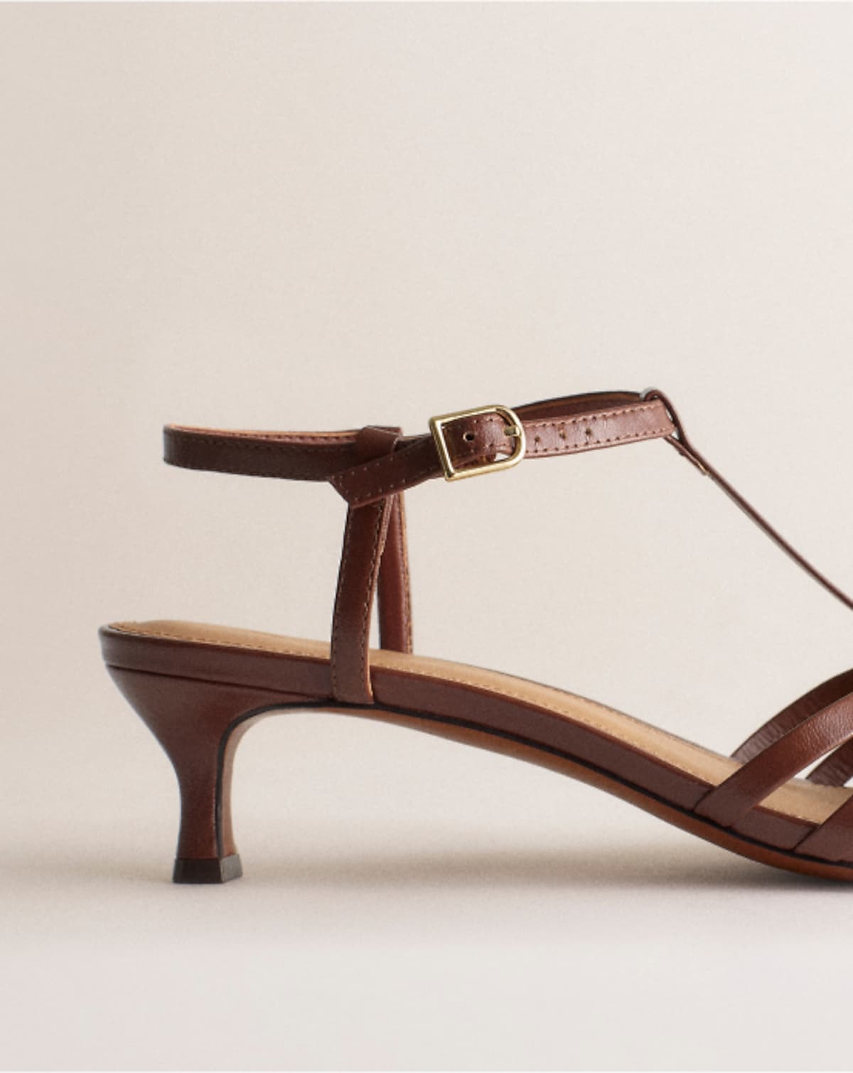 man standing in front of a parachute with classic beige shorts, white top, and a beige shirt