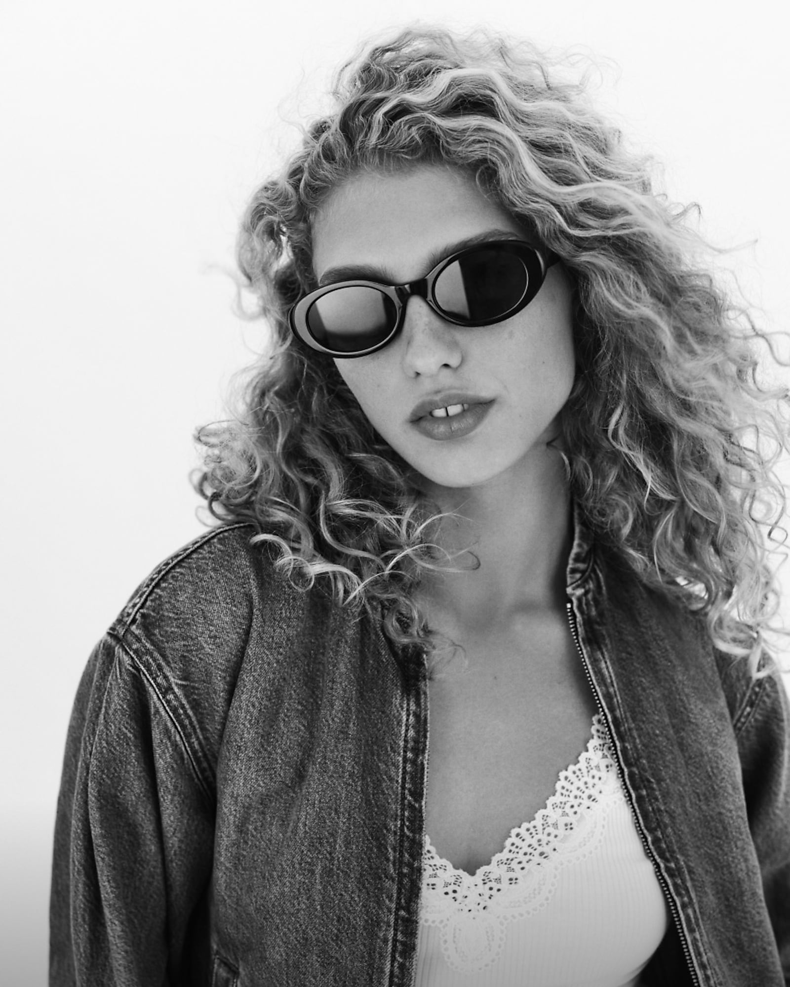 man standing in front of a parachute with classic beige shorts, white top, and a beige shirt