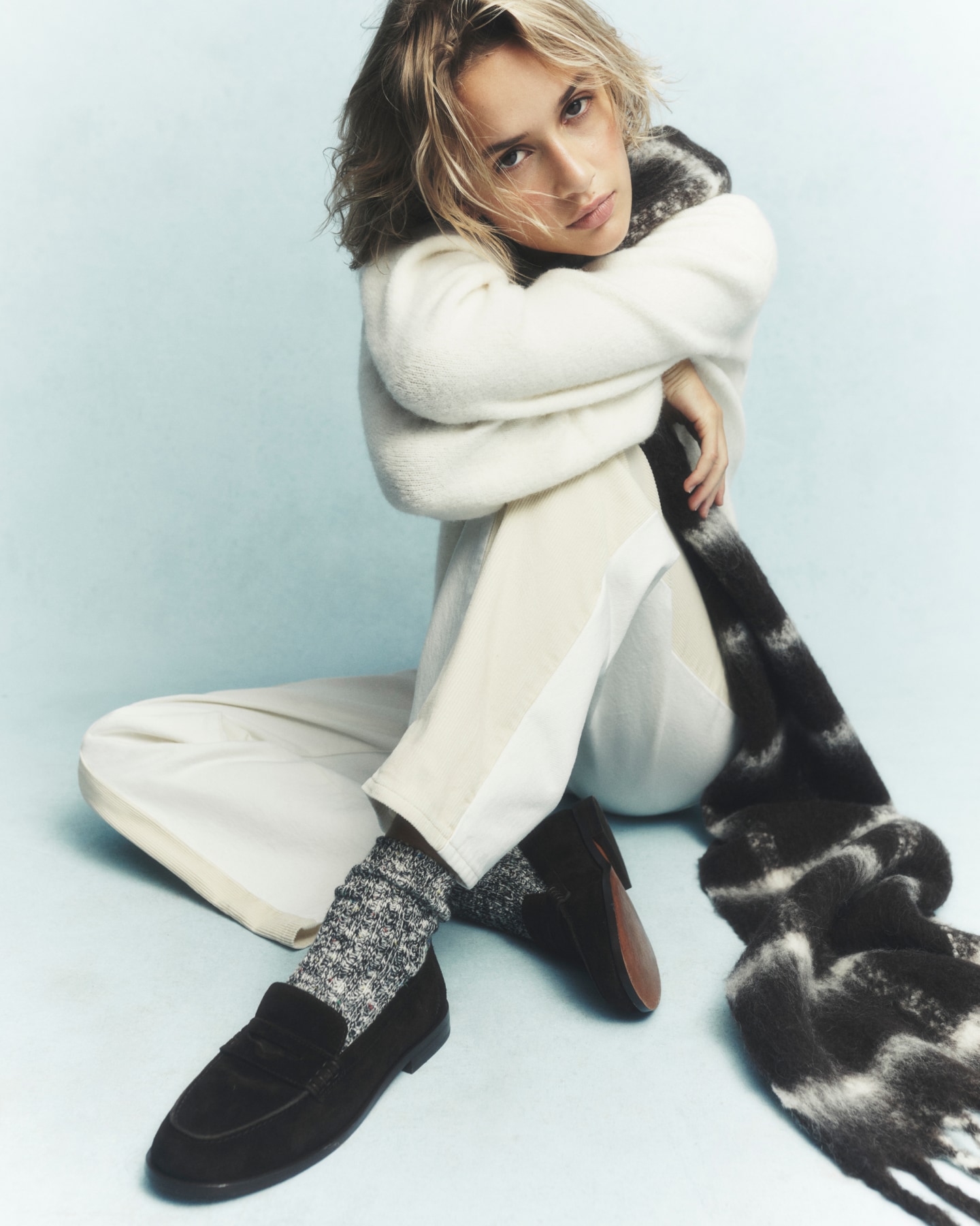 man standing in front of a parachute with classic beige shorts, white top, and a beige shirt