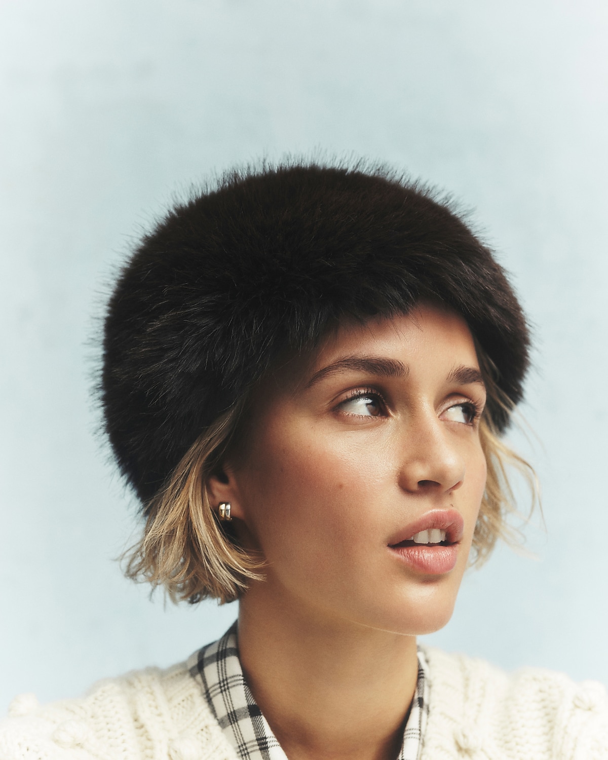 man standing in front of a parachute with classic beige shorts, white top, and a beige shirt