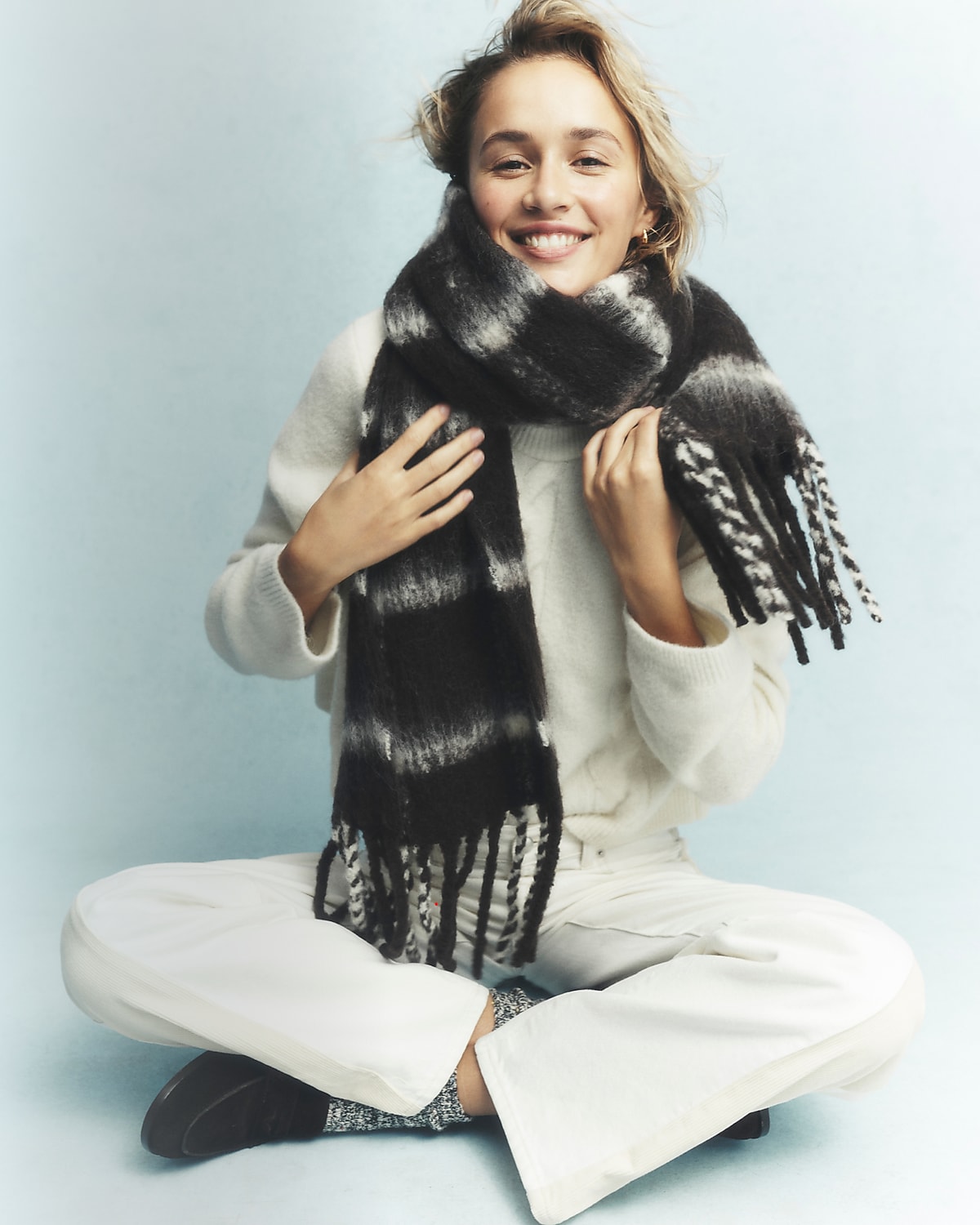 man standing in front of a parachute  with classic beige shorts, white top, and a beige shirt