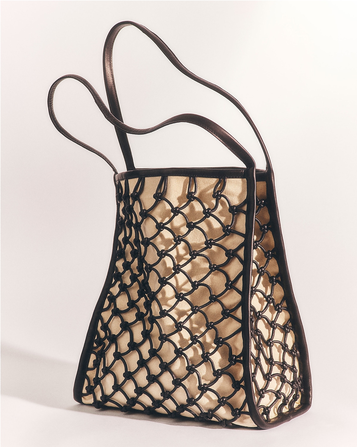 man standing in front of a parachute with classic beige shorts, white top, and a beige shirt