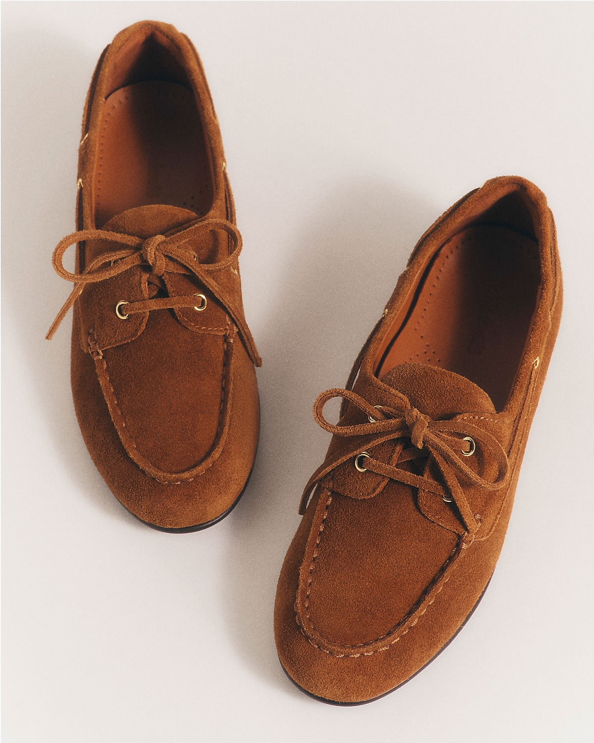 man standing in front of a parachute with classic beige shorts, white top, and a beige shirt