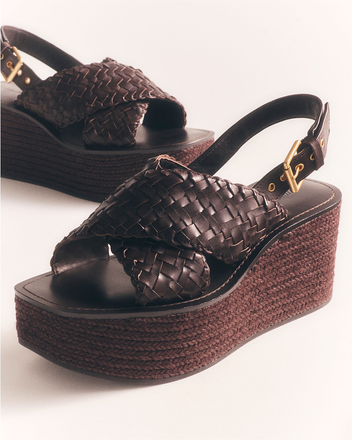 man standing in front of a parachute with classic beige shorts, white top, and a beige shirt