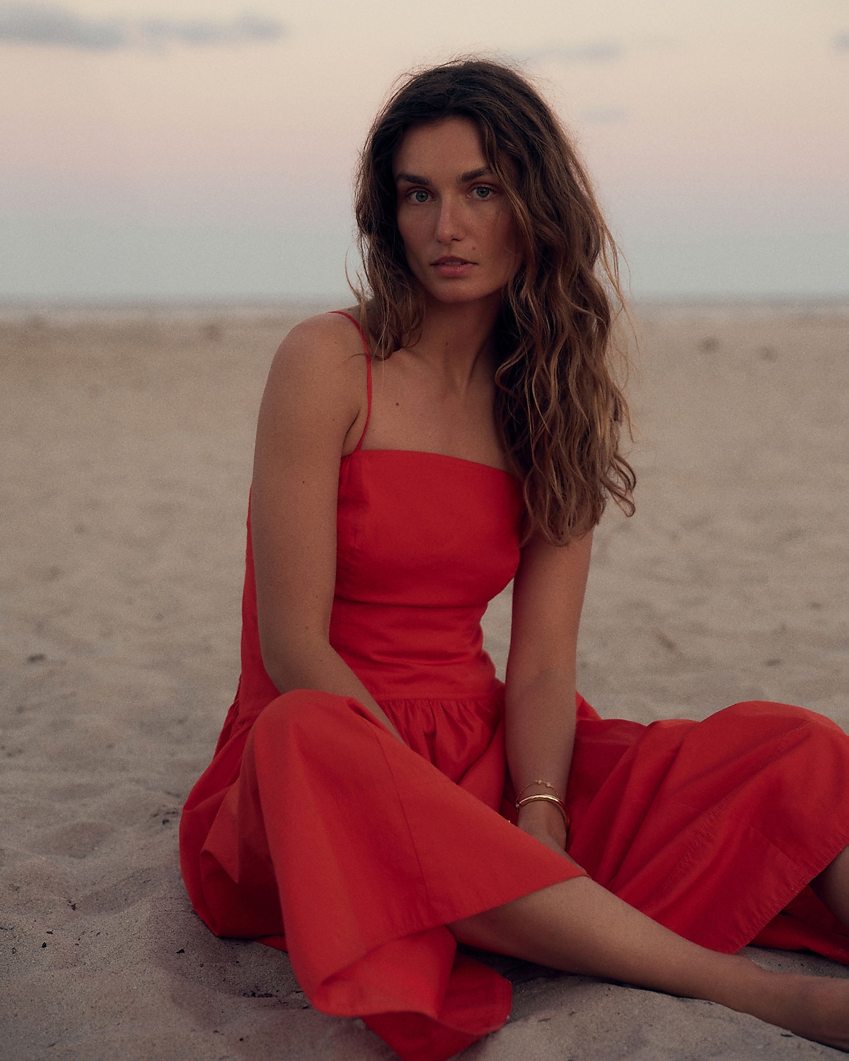 man standing in front of a parachute with classic beige shorts, white top, and a beige shirt