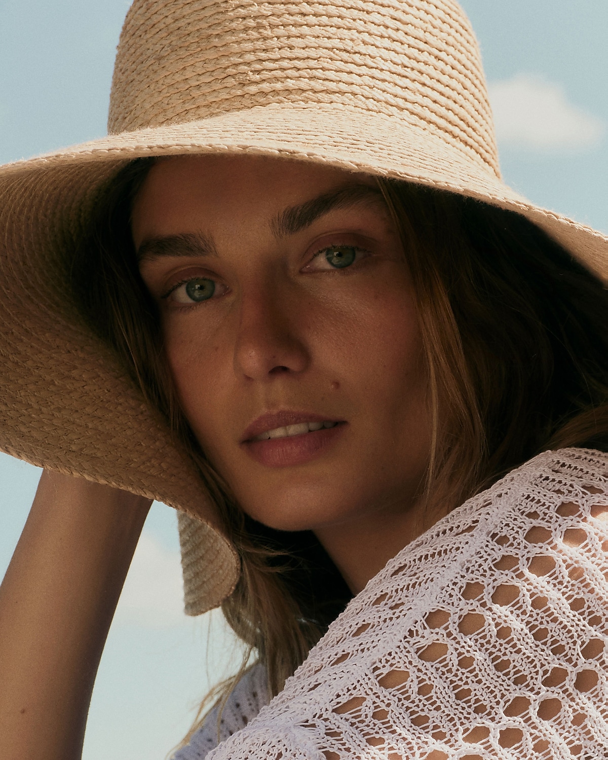 man standing in front of a parachute with classic beige shorts, white top, and a beige shirt