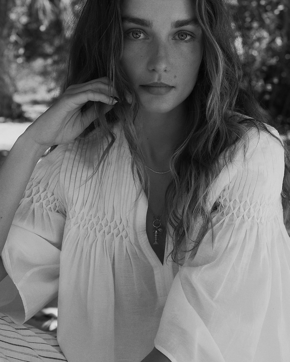 man standing in front of a parachute with classic beige shorts, white top, and a beige shirt