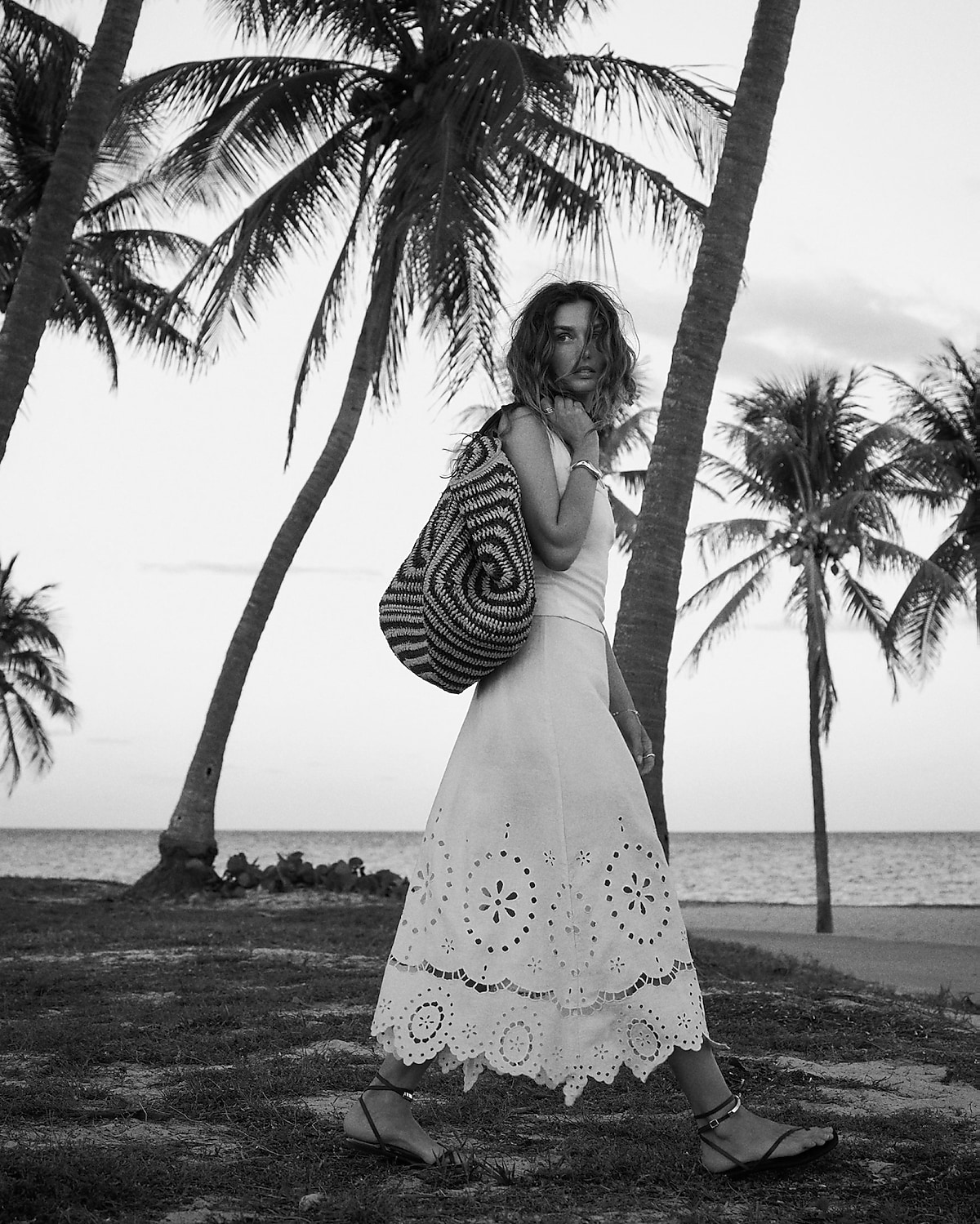 man standing in front of a parachute with classic beige shorts, white top, and a beige shirt