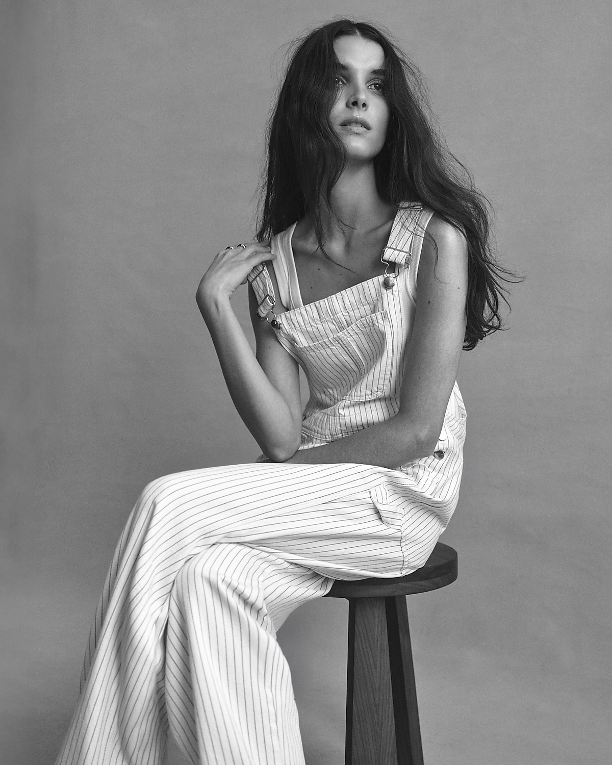 man standing in front of a parachute with classic beige shorts, white top, and a beige shirt