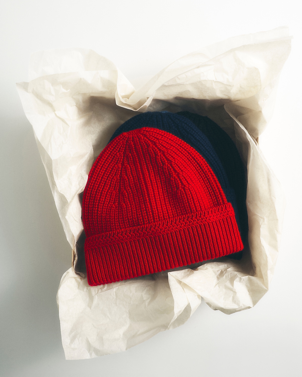 man standing in front of a parachute  with classic beige shorts, white top, and a beige shirt