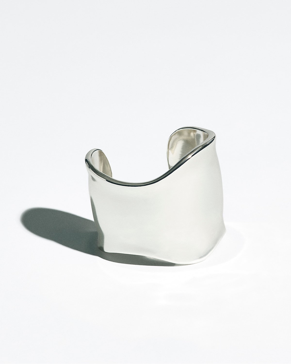 man standing in front of a parachute  with classic beige shorts, white top, and a beige shirt