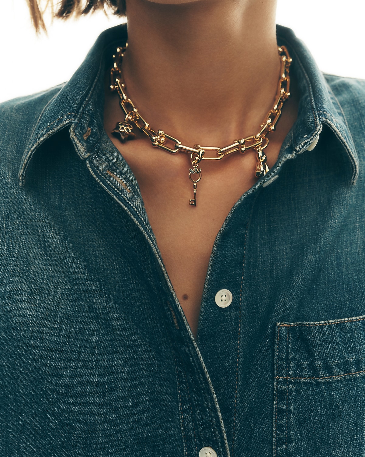 man standing in front of a parachute  with classic beige shorts, white top, and a beige shirt