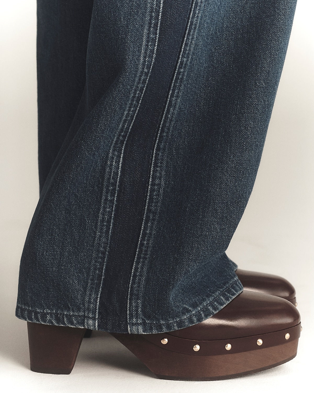 man standing in front of a parachute with classic beige shorts, white top, and a beige shirt