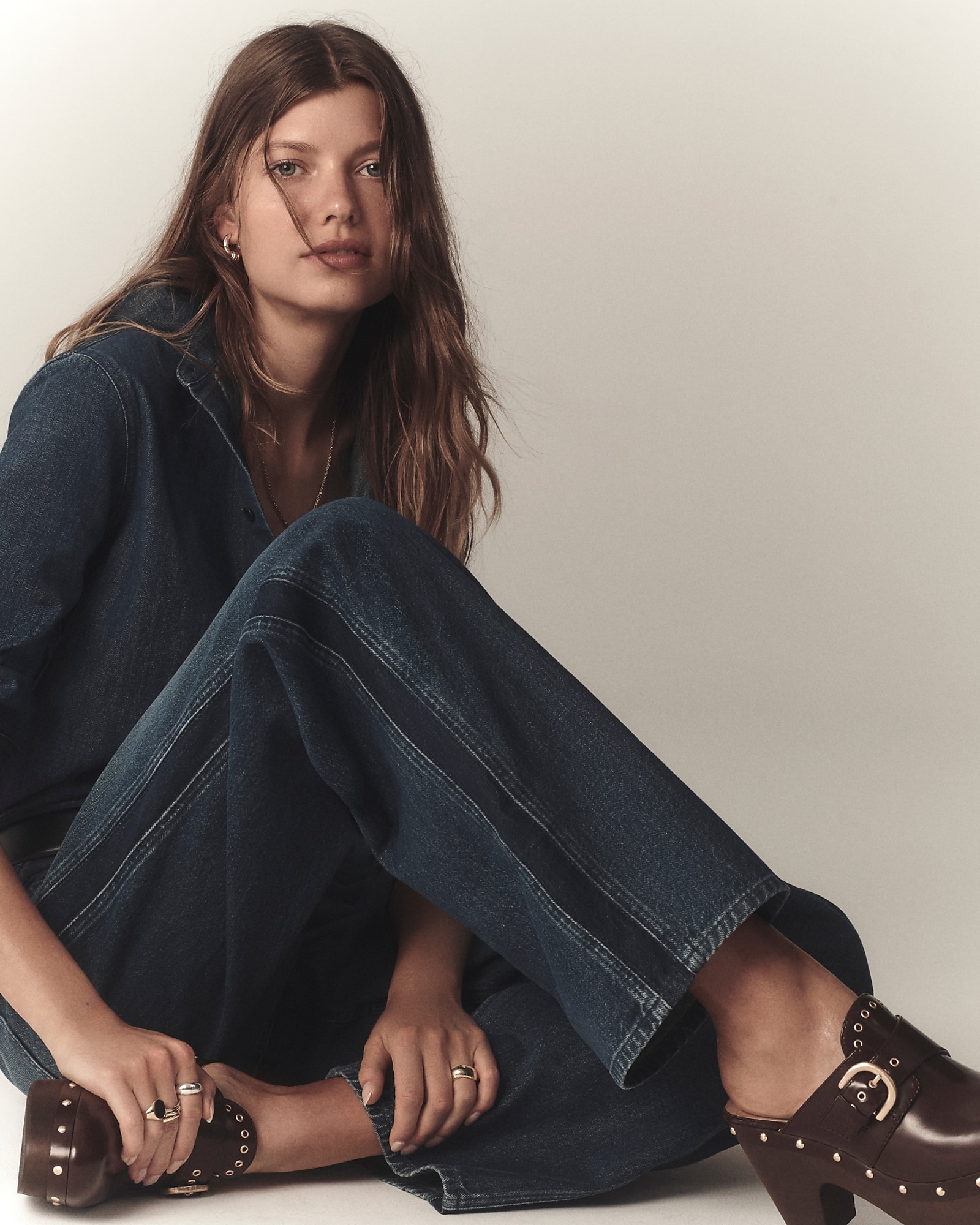 man standing in front of a parachute with classic beige shorts, white top, and a beige shirt