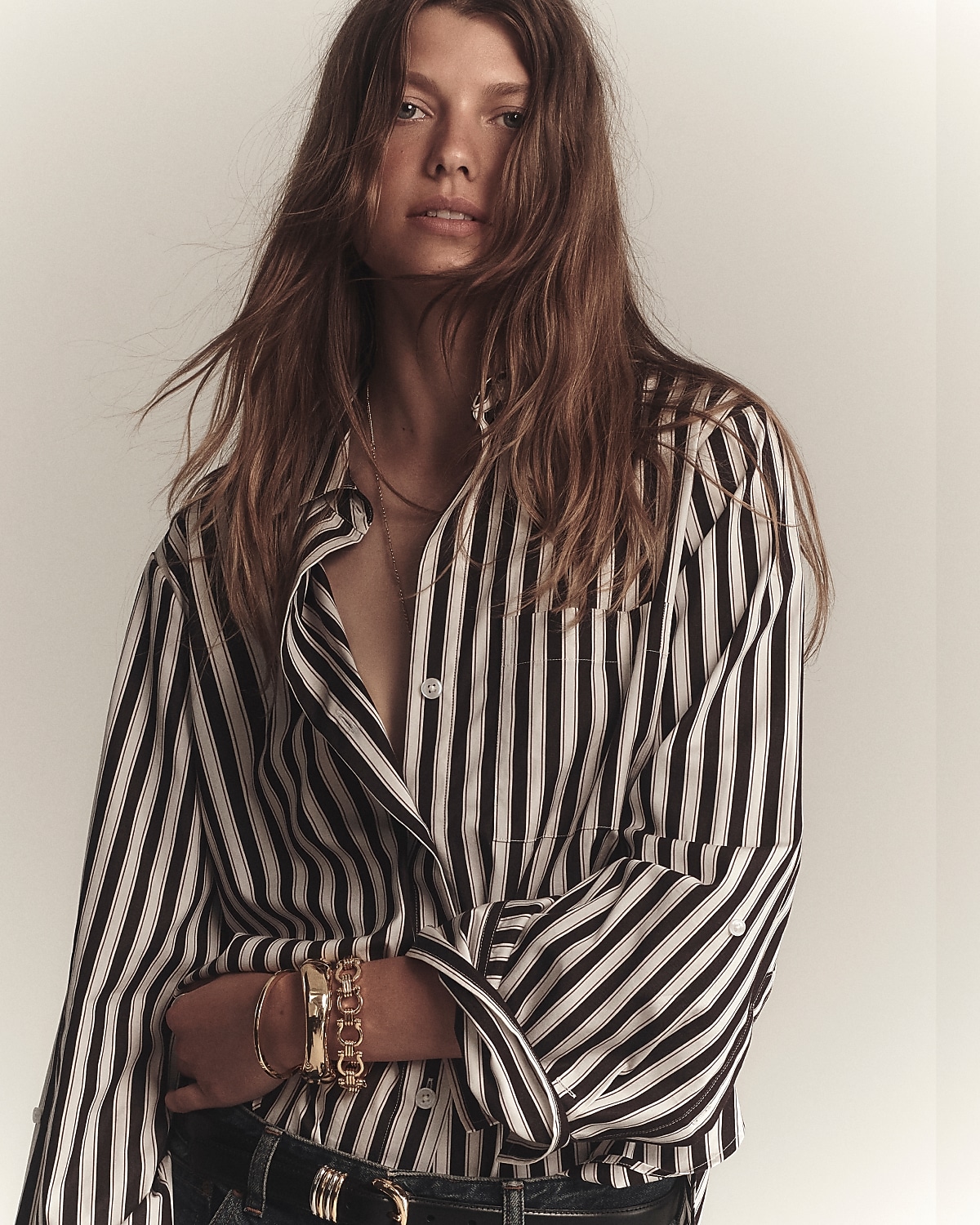 man standing in front of a parachute with classic beige shorts, white top, and a beige shirt